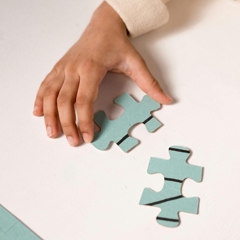 Ein Kind hält zwei große Puzzleteile in der Hand und versucht, sie zusammenzusetzen.
